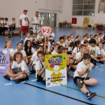 <p><span style="color: #000000;">Dzieci z Miejskiej Szkoły Podstawowej nr 2 w Piekarach Śląskich siedzące na podłodze na hali sportowej</span></p>